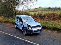 Firefighters deal with car on its side blocking the road