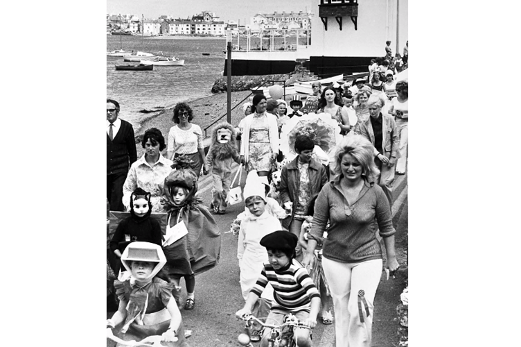 The fancy dress procession winds its way through the streets.