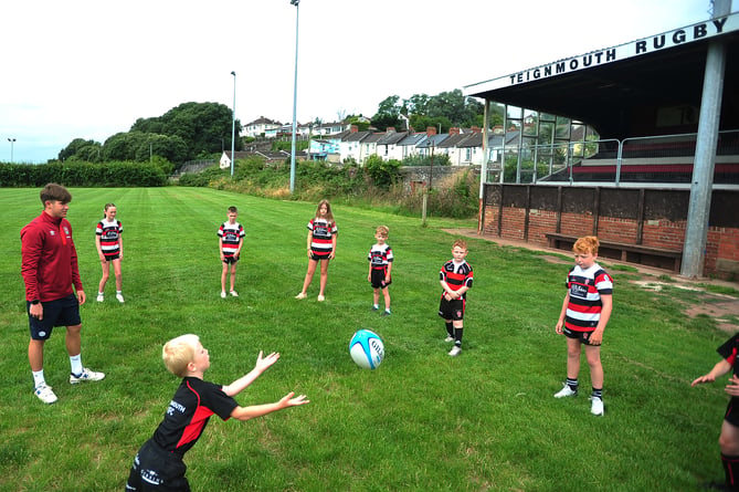 Ben Coen, of England's  Under-20 World Rugby Championship winning team, with young members of Teignmouth Rugby Club